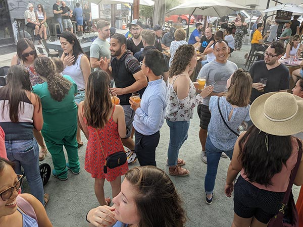 Residents retreat happy hour, outdoors with drinks, music, and company.